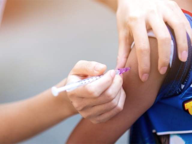 school nurse vaccinating student