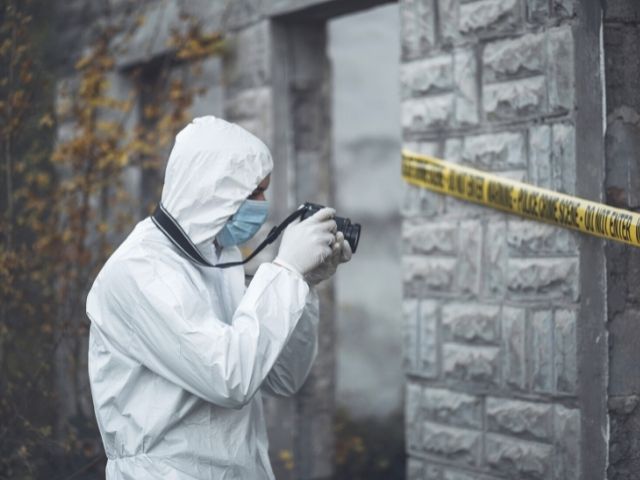 forensic specialist photographing crime scene