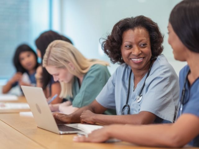 adult nursing students in classroom talking