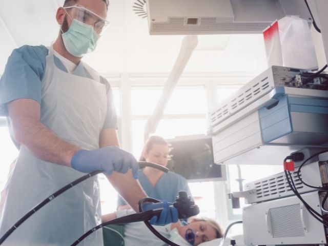 GI doctor and nurse preparing patient for endoscopy